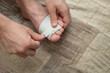© Мар'ян Філь - A close-up of hands carefully wrapping a bandage around toe, illustrating basic first aid and foot care. A young man injured his big toe while playing football, injury management