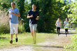 © auremar - men running together on the trail in the green forest