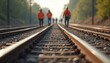 © Viktor - Workers in hard hats and vests walk on train tracks. Group travels on railway lines during daytime. Team works on industrial site, maintaining railroad infrastructure for safe travel.
