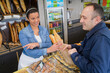 © auremar - man buying fresh baguette from a female baker