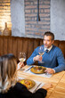© BGStock72 - Couple enjoys dinner with drinks at a restaurant in the evening