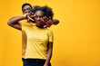 © SHOTPRIME STUDIO - Young couple posing playfully in matching yellow outfits against a vibrant yellow background, showcasing joy, connection, and style