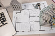 © RomanR - US dollar banknotes with house plan and wood texture samples on architect desk, renovation budget concept