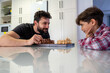 © Antonio Recena - father and son playing chess at home