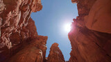 Red rock canyon walls against blue sky, upward view