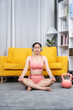 © Kritdanai - Serene Yoga Session: A young woman finds inner peace through yoga in her cozy home, practicing mindfulness and meditation. The ambiance is one of tranquility and wellness.