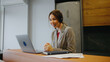 © tol_u4f - Woman at a desk using a laptop and headset while talking to a client in an office setting during daytime