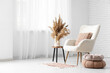 © Pixel-Shot - Interior of light living room with armchair, table and pampas grass in vases