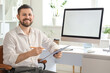 © Pixel-Shot - Young businessman working with clipboard and blank computer at table in office