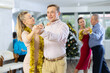 © JackF - Couples dancing during Christmas - men and women dancing tango or samba next to the Christmas tree