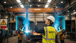 © ViskBx - Female safety officer supervising welding operations in industrial factory setting