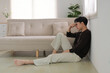 © amnaj - Stressed young man sitting on floor at home, feeling unhappy and lonely, experiencing mental health issues