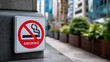 © Laura - No smoking sign prohibiting tobacco and electronic cigarettes mounted on concrete wall in public area with foreign language text, health regulation, with copy space