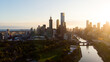 © AmazingAerialAgency - Aerial view of Melbourne's skyline bathed in the warm glow of the setting sun, Yarra River reflecting the light, Melbourne, Victoria, Australia.