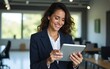 © Lila - Happy latin business woman uses tablet device. Smiling mature female executive working at office, using fintech tab application. Person in formal wear looks at screen. Happy, satisfied. High quality