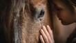 © kirania - Close up of a young girl gently touching a horses face with a look of deep connection and trust.