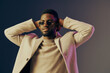 © SHOTPRIME STUDIO - Stylish young Black man in sunglasses showcasing confidence against a gradient backdrop, exuding modern fashion and contemporary lifestyle trends