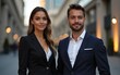 © Thomas - A couple stands together, dressed in smart business attire, exuding confidence. Their serious expressions and poised demeanor complement the stylish urban backdrop illuminated by soft lights