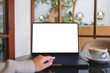 © Farknot Architect - Mockup image of a woman working and typing on laptop computer with blank white desktop screen in cafe