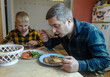 © Siniehina - A man and his 9-year-old son eat together at the table