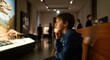 © rdkcho - Young boy intently watching a dinosaur exhibit in a natural history museum.
