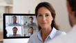© Thares2020 - A woman participates in a video conference call with multiple colleagues in an office setting