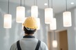 © Marina Demidiuk - Wiring a New light fixture installation and electrical work. Electrician man installing a black lamp home lighting and spot loft style on ceiling. Electrical industry and design. Interior lighting