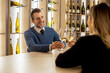 © BGStock72 - Couple enjoys conversation over drinks at a bar in an upscale setting