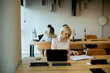 © BGStock72 - Woman reading documents at modern office workspace during day