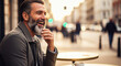 © OlehStock - Salt-and-pepper beard man laughing hand gently touching beard city street cafe table blurred city background warm daylight happy moment