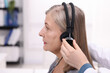 © New Africa - Hearing test. Doctor adjusting patient's audiometric headphones in clinic, closeup