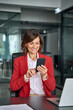 © Stock 4 You - 40s middle aged business woman holding mobile cell phone cellphone in office. Focused mature professional ceo entrepreneur businesswoman using smartphone for work sitting at desk workplace. Vertical
