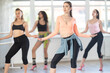 © JackF - Confident fit young adult woman wearing casual activewear performing sensual and modern high heels choreography during group class in sunlit dance studio..