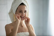 © fizkes - Daily dental care. Head shot portrait in bathroom mirror beautiful young lady with towel around body hair cleaning teeth with soft eco bamboo dental floss enjoying healthy smile fresh breath every day