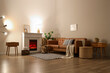 © Pixel-Shot - Interior of living room with sofa, glowing lamps, bedside tables and firewood near fireplace in evening