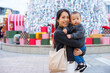 © leungchopan - Mother holding baby in front of christmas decoration