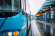 © Sergej Gerasimov - Blue city bus waiting at a rainy urban transportation terminal with blurred background and illuminated headlights on a wet platform
