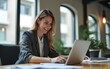 © Joseph - Smiling businesswoman using laptop in office. Side view of content middle aged businesswoman using laptop computer in modern office. Technology and business concept. High quality