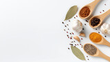Different spices and herbs on wooden spoons with garlic and bay leaves