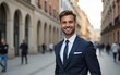 © Abigail - Happy young businessman in the city. Portrait of a smiling Caucasian male in a business suit standing outdoors on a summer day. Handsome European man in a classic suit standing on the street.