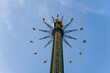 © Travel 'n' Lifestyle - View of riders twirling high on a chain swing ride against the stark blue sky, creating a dizzying, thrilling spectacle, Vienna, Vienna, Austria.