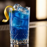 Vibrant blue cocktail with lemon twist and ice cubes on reflective surface