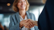 © Kateryna - Faceless happy businesswomen shaking hands while greeting in office heavily defocused workplace background anonymous professionals with introduction corporate networking moment