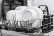 © wedmoments.stock - Dishwasher interior showcasing neatly arranged white plates in a metal rack, highlighting cleanliness and organization in modern kitchen appliance design with copy space