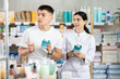 © JackF - In sales area of pharmacy, guy examines packaging of mouthwash solution, read characteristics and properties, check expiration date, storage conditions. Pharmacist in background offer similar product