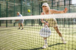 © JackF - Mature sporty woman playing padel game in court on sunny day