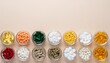 © Iwan - A collection of various colorful pills and capsules arranged in two rows on a light beige background.