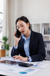 © David - Young business financial documents Asian woman phone call at desk , near the window in workplace office
