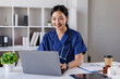 © David - Nurse, woman and studying with books at desk for medical research, information and knowledge. Home, healthcare and reading with laptop in living room for diagnosis reference, guide and treatment plan