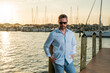 © Olena - Rich summer business man near the yacht. Portrait of fashion male model outdoor. Fashion male posing near yachts. Man in urban style. Rich man at yacht club. Man in gulf with seaview and luxury ships.